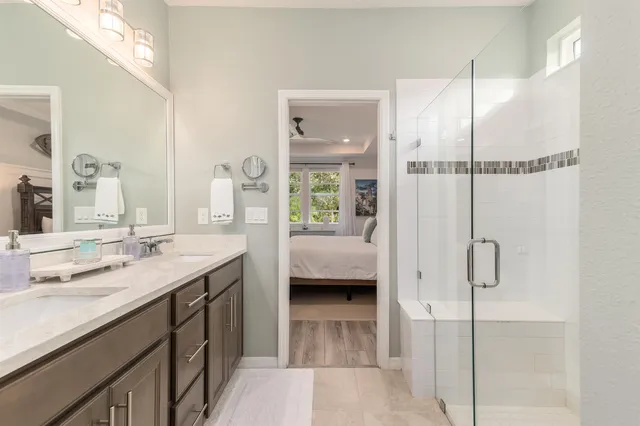 a en suite bathroom with a granite countertop sink and a mirror
