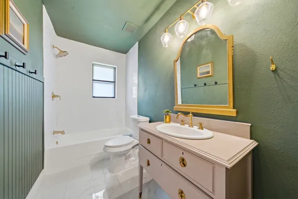a bathroom with a sink mirror vanity and toilet