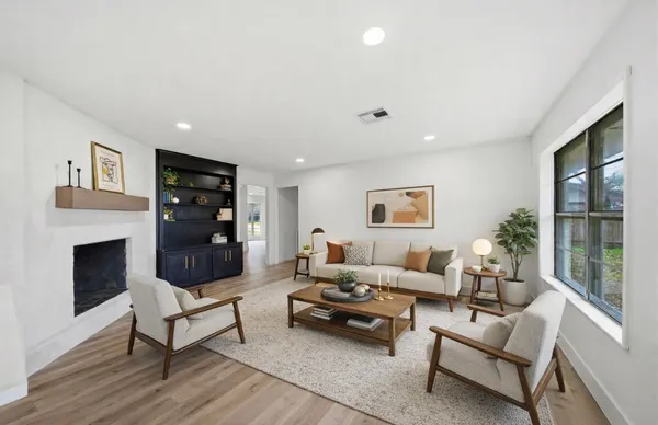a living room with furniture a fireplace and a floor to ceiling window