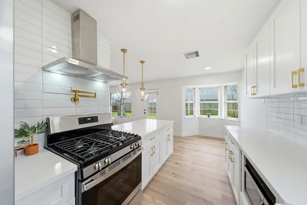 a kitchen with stove and cabinets