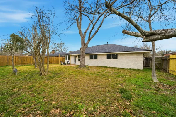 a backyard of a house with large trees and a small yard