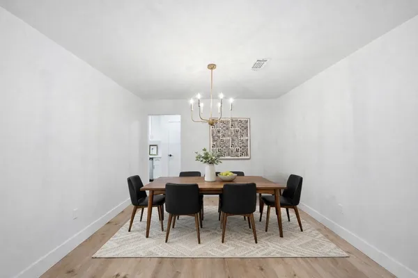 a view of a dining room with furniture and chandelier