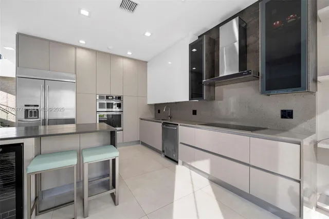 a kitchen with cabinets and chairs