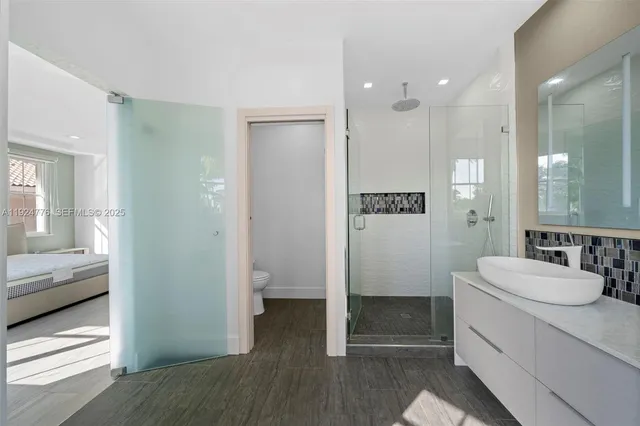a bathroom with a sink a toilet and shower