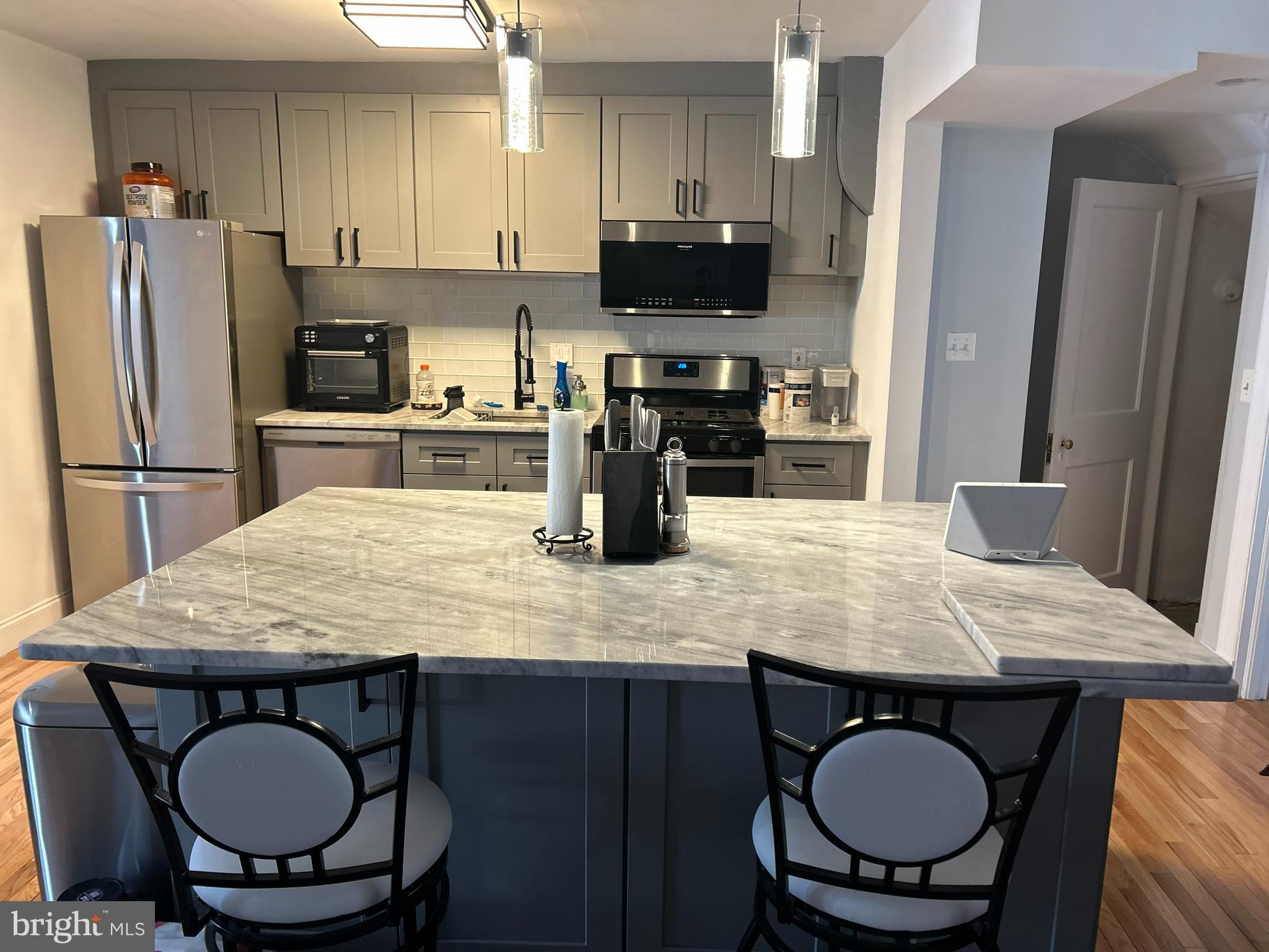4211 Wickford Road Baltimore, MD 21210 - Photo 5 of 16 a kitchen with stainless steel appliances granite countertop a stove a refrigerator a sink a dining table and chairs