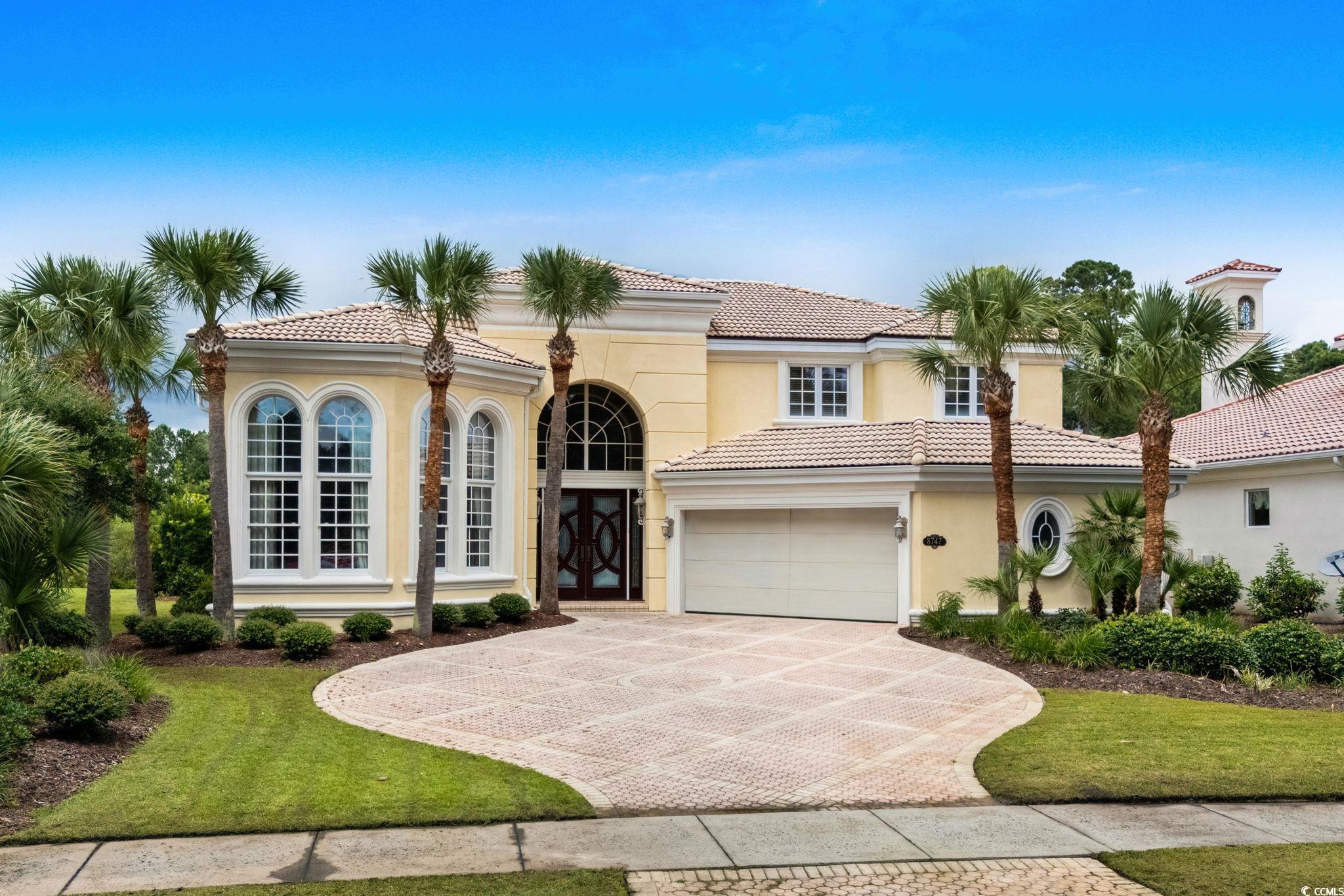 Mediterranean / spanish-style house with stucco siding, french doors, decorative driveway, and a tiled roof