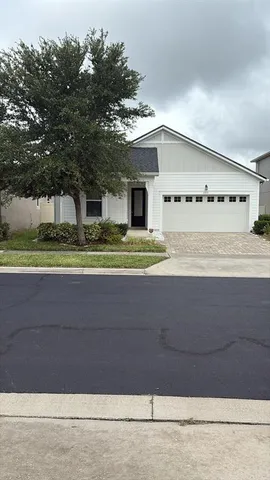 a view of house with a yard and large tree