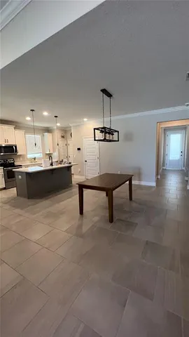 a living room with kitchen furniture and a chandelier