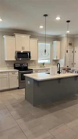a kitchen with kitchen island sink stove and refrigerator