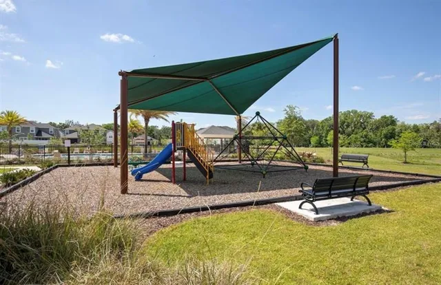 a view of a swimming pool with lawn chairs under an umbrella