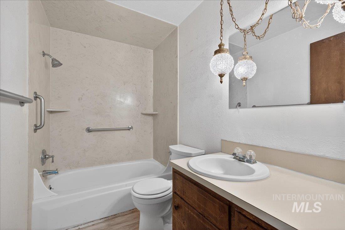 10035 W Lane Boise, ID 83709 - Photo 14 of 32 Bathroom featuring vanity, a textured wall, shower / tub combination, and light wood-type flooring