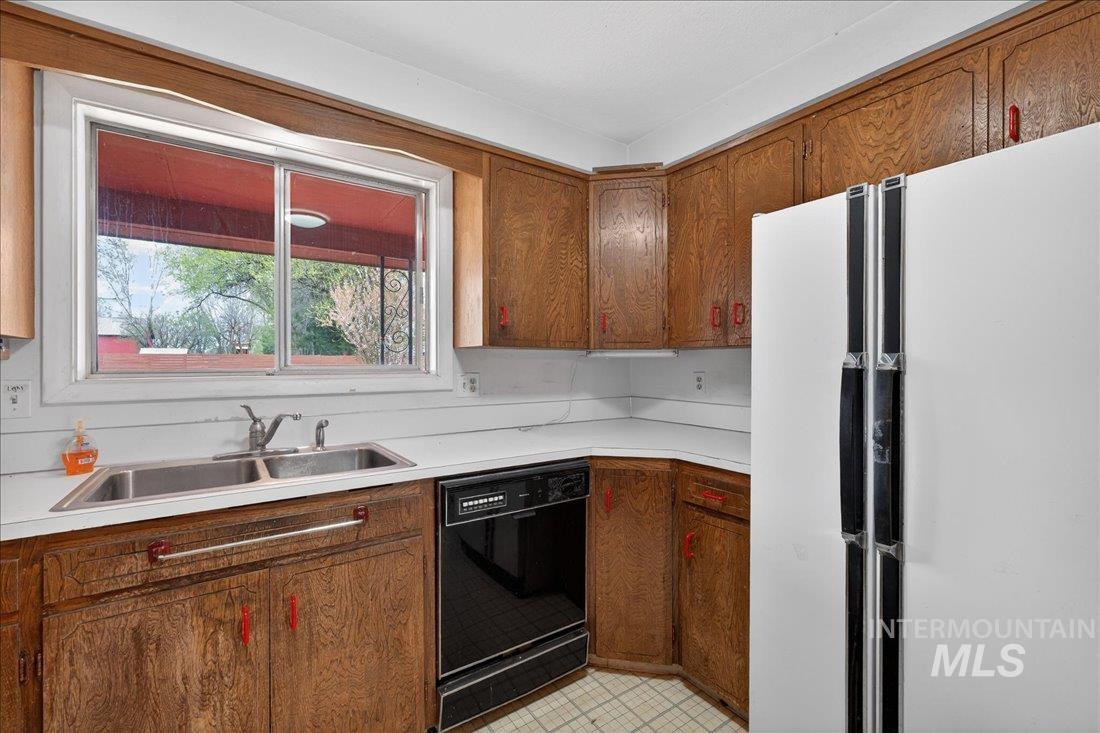 10035 W Lane Boise, ID 83709 - Photo 18 of 32 Kitchen featuring freestanding refrigerator, light countertops, dishwasher, and wood finish cabinetry