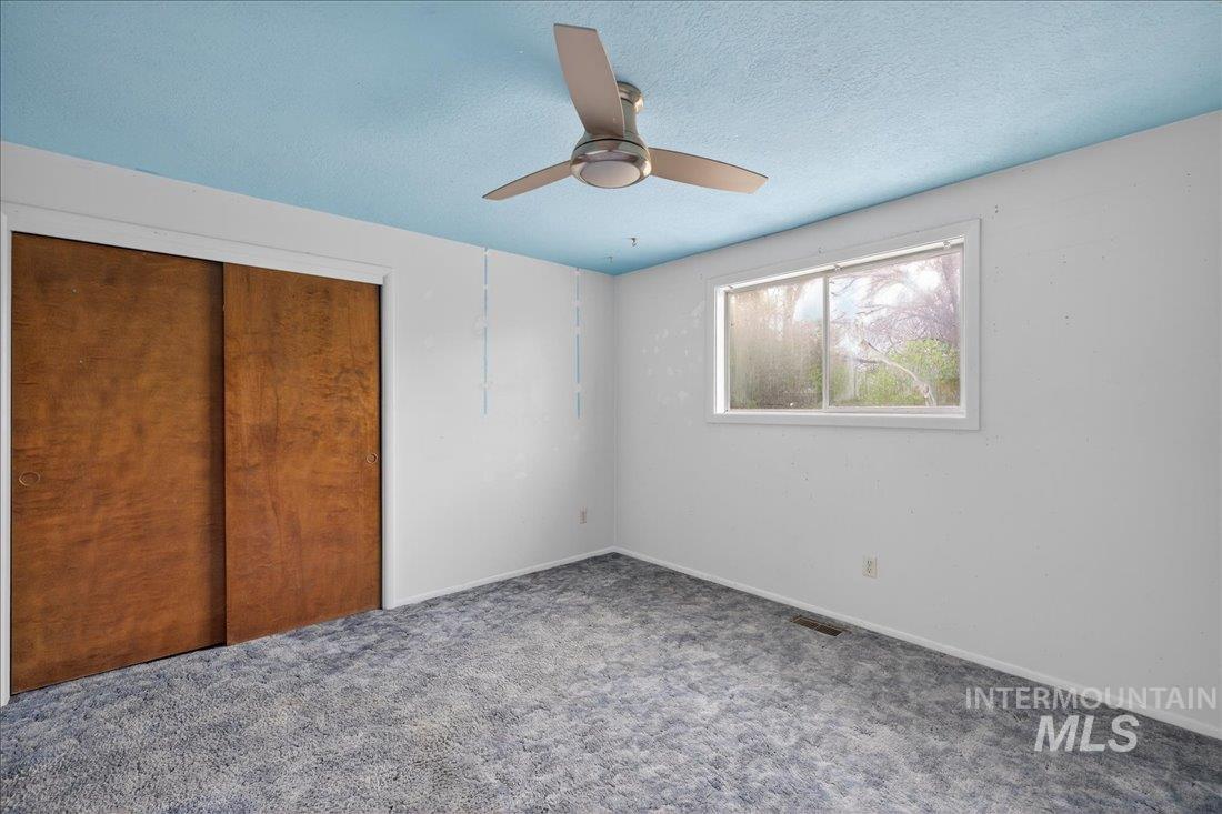 10035 W Lane Boise, ID 83709 - Photo 21 of 32 Unfurnished bedroom with a closet, carpet floors, a textured ceiling, and ceiling fan