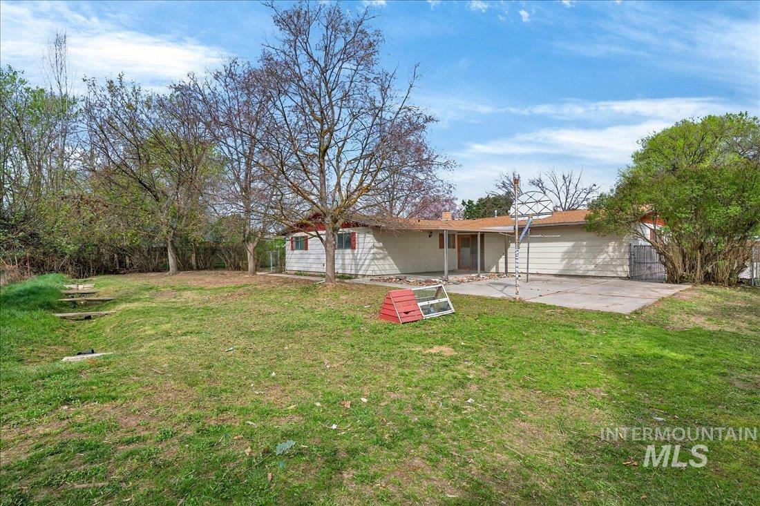 10035 W Lane Boise, ID 83709 - Photo 31 of 32 Back of house featuring a patio, a lawn, and a chimney
