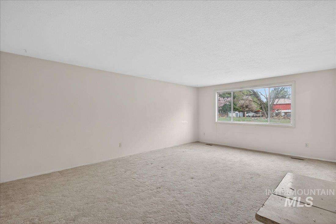 10035 W Lane Boise, ID 83709 - Photo 10 of 32 Carpeted empty room with a textured ceiling and baseboards
