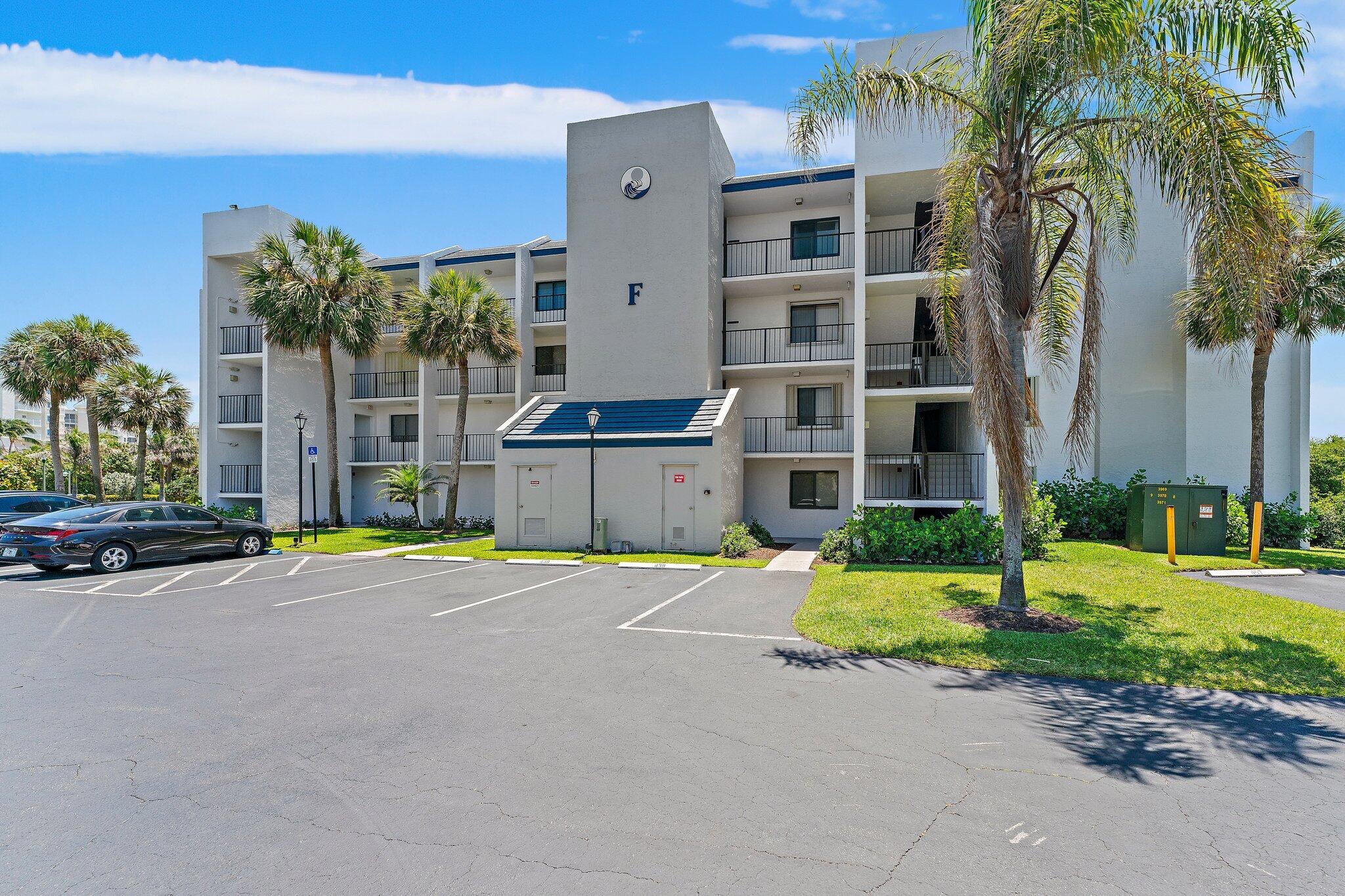 1605 South U Highway, Unit F 106 Jupiter, FL 33477 - Photo 18 of 43 a view of a building with a yard and palm trees