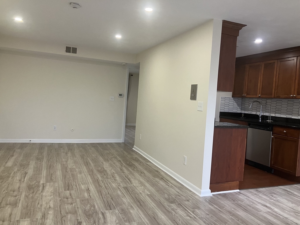 a view of kitchen with granite countertop cabinets and wooden floor
