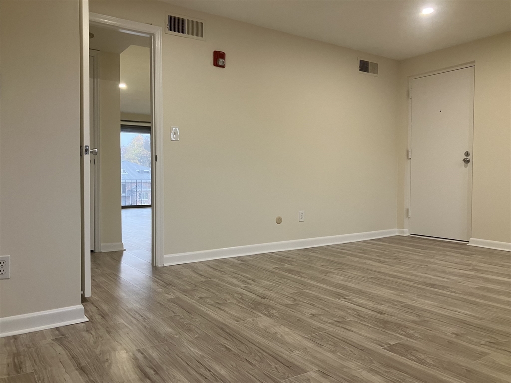 360 Neponset Street, Unit 605 Canton, MA 02021 - Photo 13 of 21 a view of an empty room with wooden floor and a bathroom