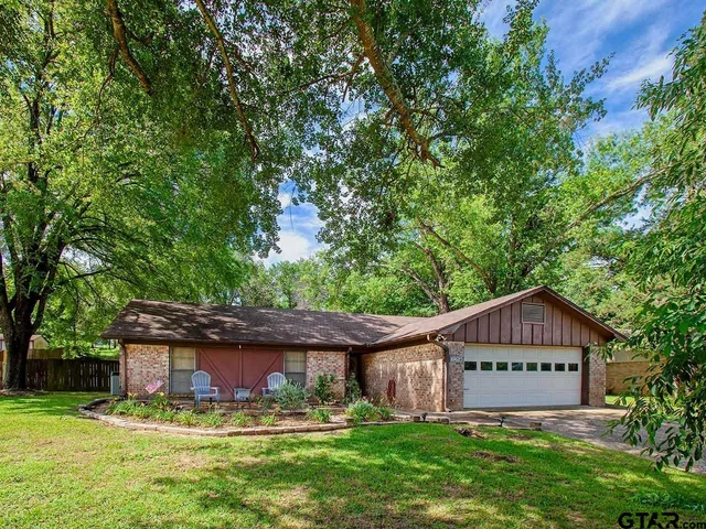 a sign board with a house in the background
