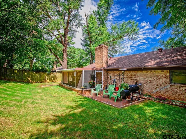 a view of a patio with table and chairs potted plants and a large tree