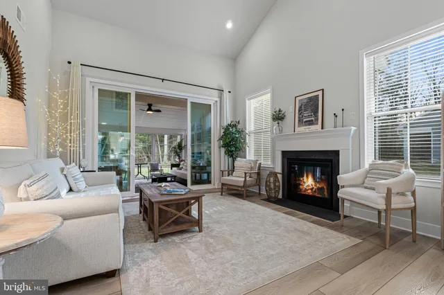 a living room with furniture a clock on wall and a fireplace