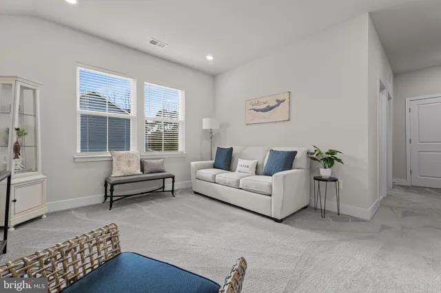 a bed sitting in a spacious bedroom next to a window and a chair