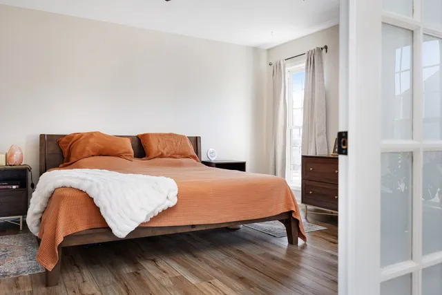 a living room with a mirror and a wooden floor
