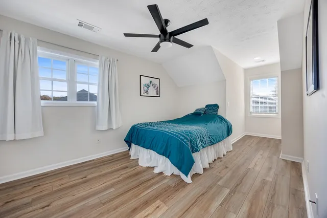 a view of a bedroom with wooden floor