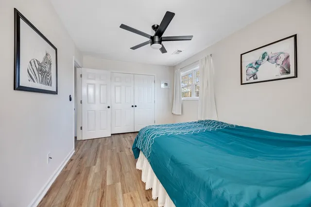 a very nice looking bedroom with wooden floor and furniture