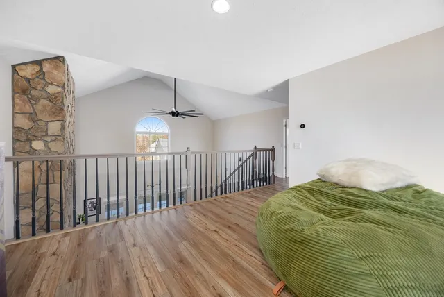 a view of empty room with wooden floor and fence