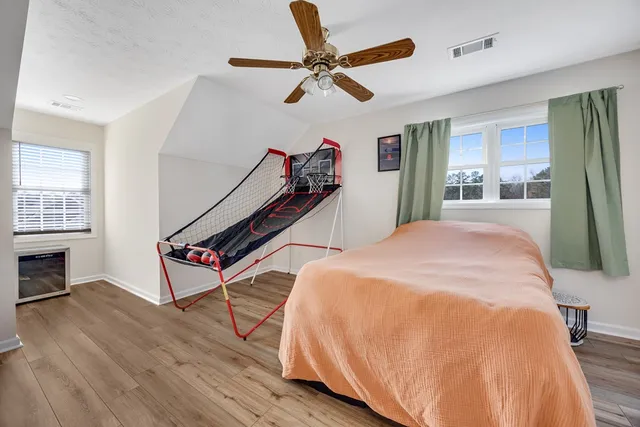a view of a backyard with large tree and wooden fence