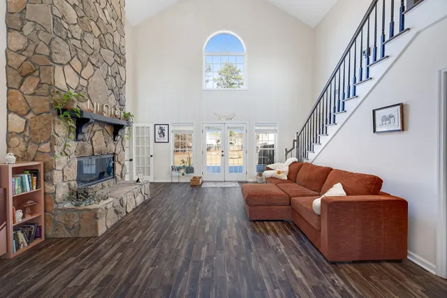 a living room with furniture stairs and a wooden floor