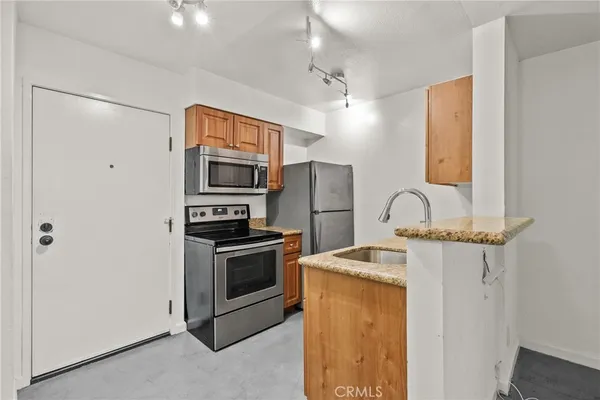 a kitchen with stainless steel appliances granite countertop a stove and a refrigerator