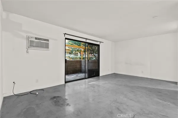 an empty room with a fireplace and windows