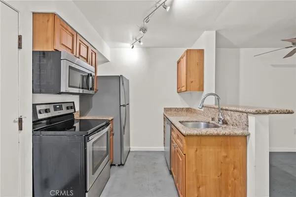 a kitchen with stainless steel appliances granite countertop a sink stove and refrigerator