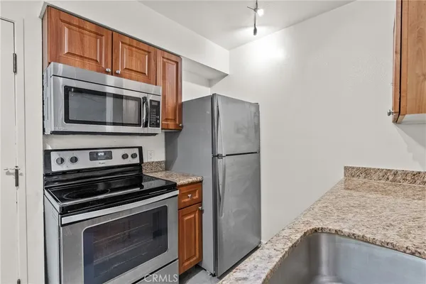 a kitchen with granite countertop cabinets and steel stainless steel appliances
