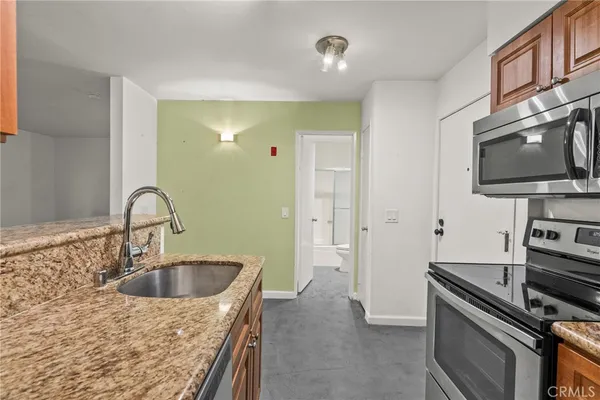 a kitchen with sink a stove and a microwave