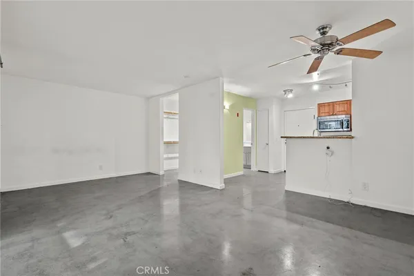 an empty room with closet and fan