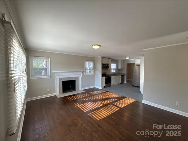 an empty room with windows and fireplace