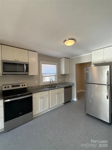 a kitchen with stainless steel appliances a stove a sink and a refrigerator
