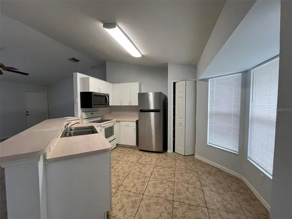a kitchen with stainless steel appliances granite countertop a refrigerator a stove and a sink