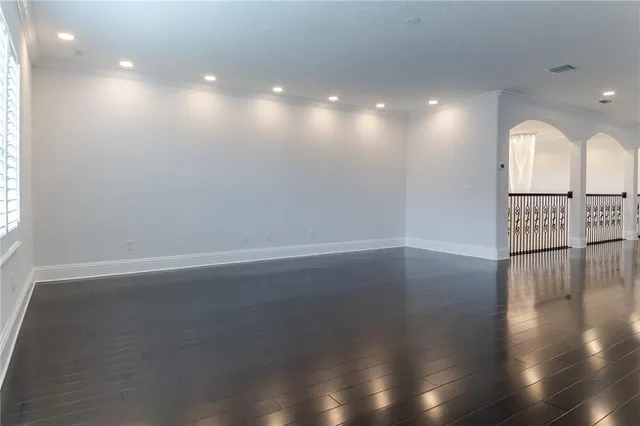 an empty room with wooden floor and windows in it
