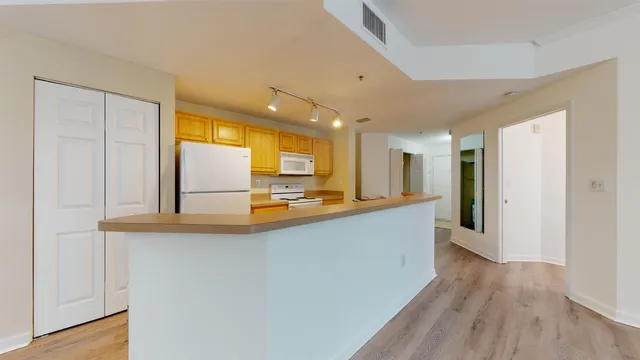 a view of a kitchen with a sink and wooden floor