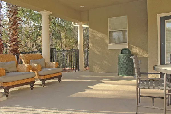 a patio with yard glass top table and chairs