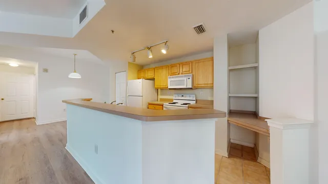 a view of a kitchen with a sink and dishwasher with wooden floor