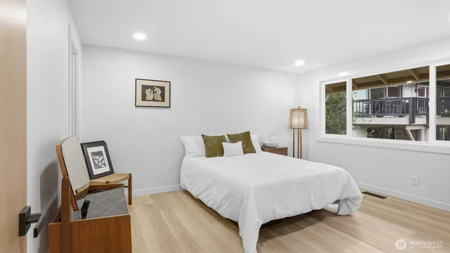 a bedroom with a bed wooden floor and window