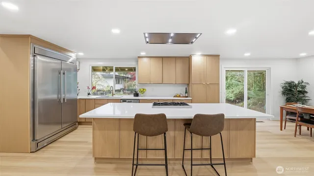 a kitchen with kitchen island granite countertop a sink and refrigerator
