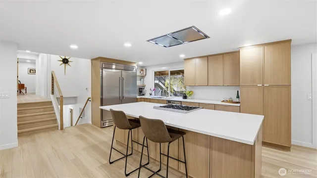 a kitchen with a table chairs refrigerator and cabinets
