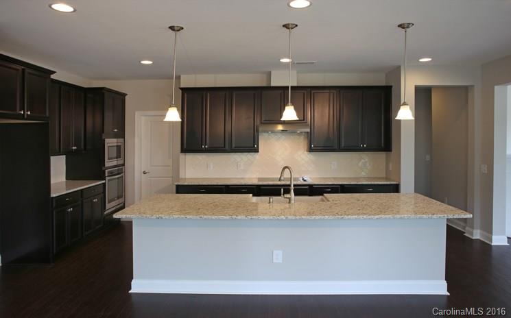 974 Emory Lane, Unit 111 Fort Mill, SC 29708 - Photo 5 of 22 a large kitchen with stainless steel appliances kitchen island a large counter top and a refrigerator