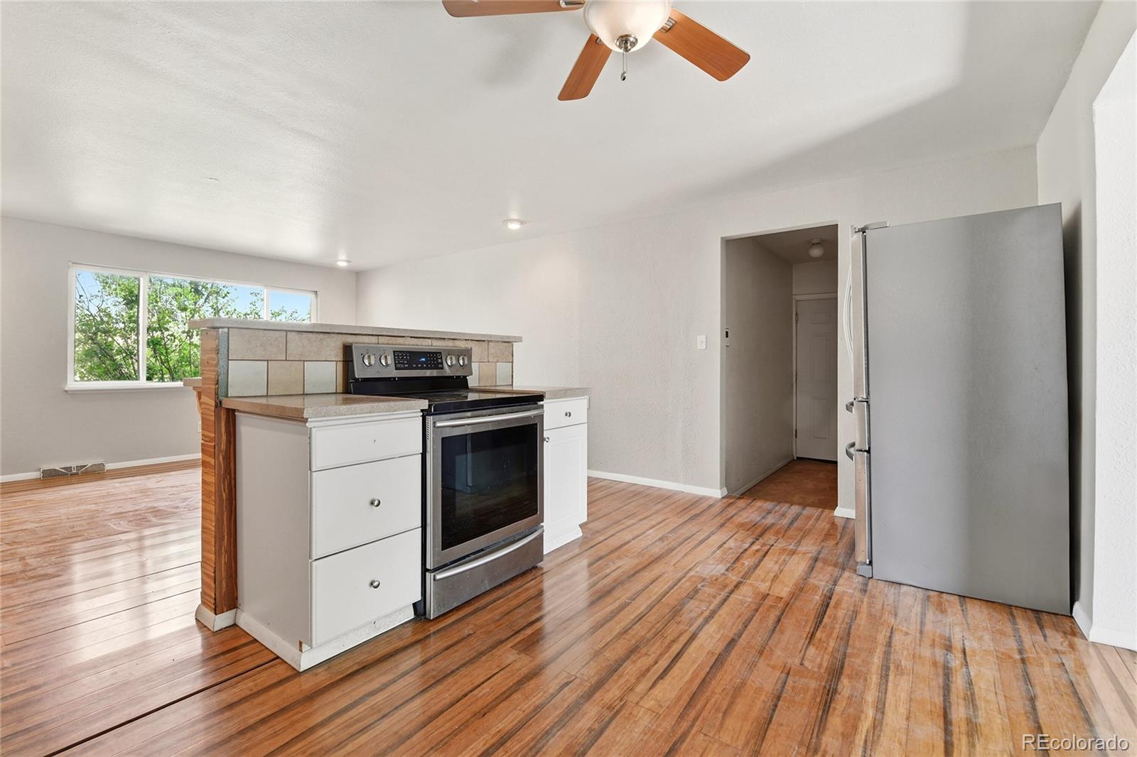 7461 Webster Street Arvada, CO 80003 - Photo 9 of 31 a kitchen with wooden floors and white stainless steel appliances